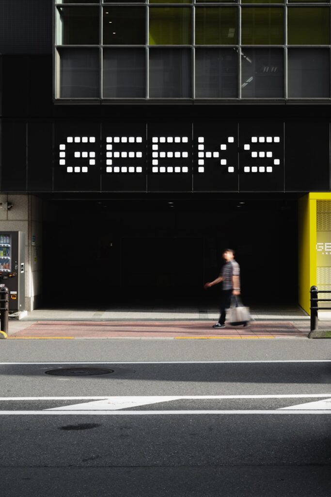 A man walking down a street next to a tall building